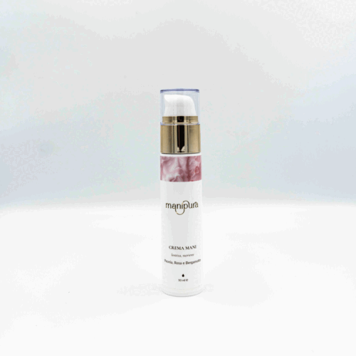Flacone di crema mani Manipura fotografato dall’alto con tappo trasparente appoggiato accanto, su sfondo bianco.