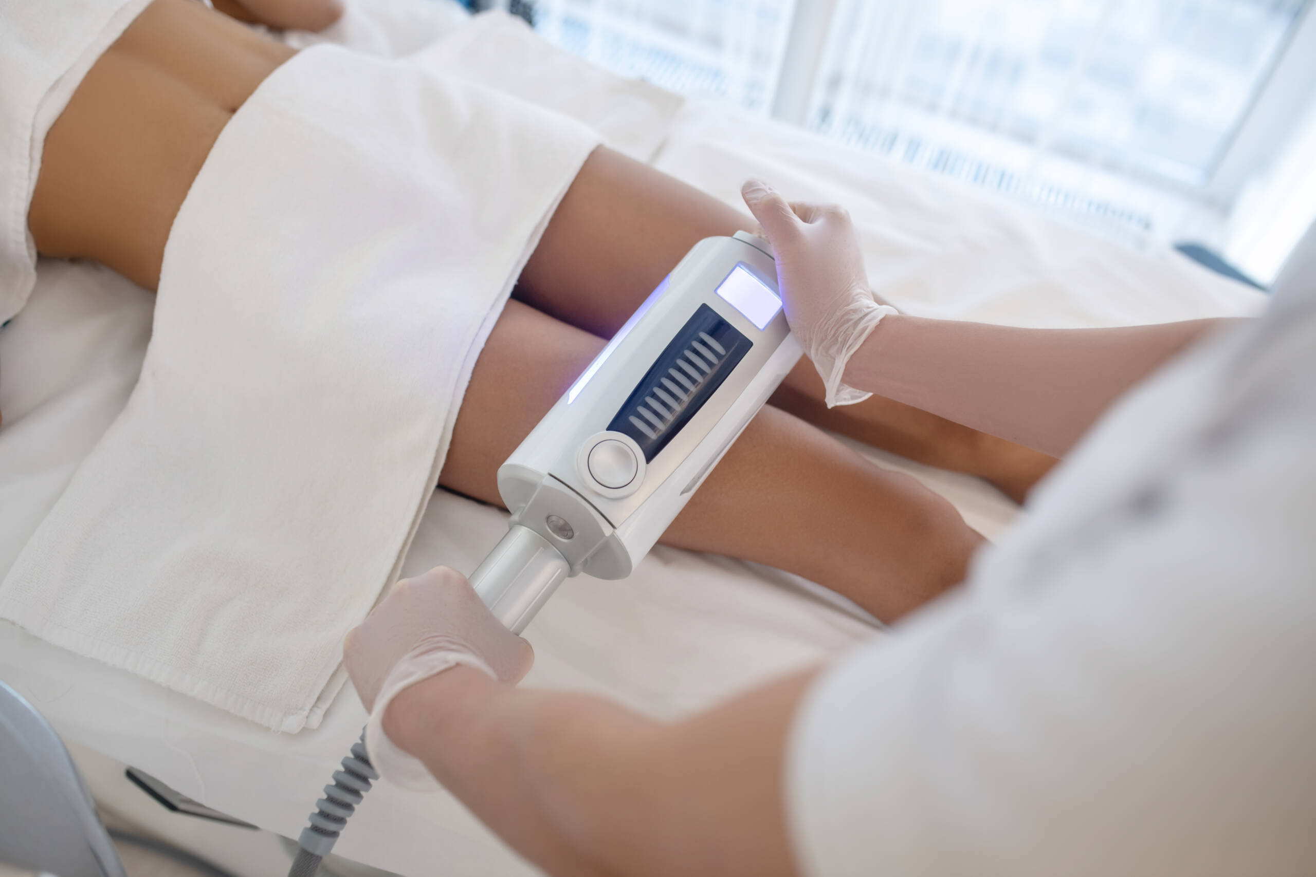 Tecnica estetica con apparecchiatura professionale applicata alle gambe per un trattamento corpo rimodellante.