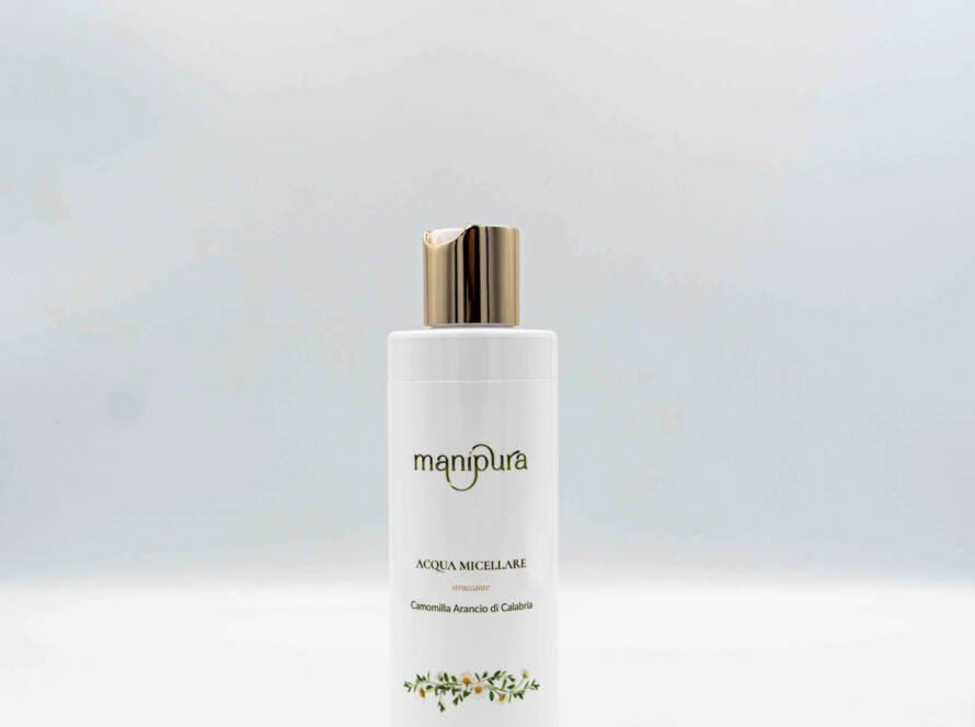Flacone frontale di Acqua Micellare Manipura alla Camomilla e Arancio di Calabria, tappo dorato su sfondo bianco.