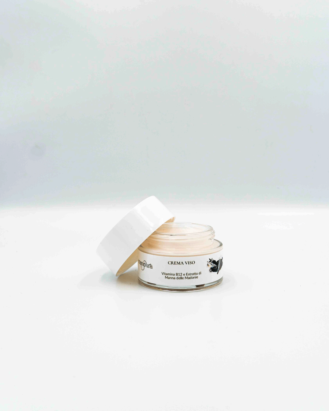 Vasetto aperto della Crema Viso alla Vitamina B12 ed Estratto di Manna delle Madonie di Manipura su sfondo bianco.
