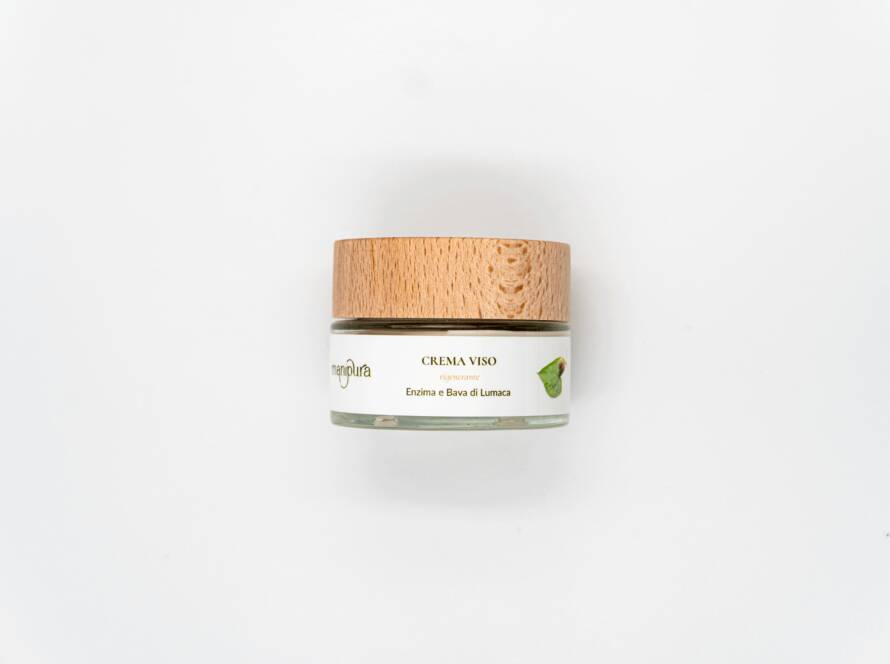 Barattolo della crema viso rigenerante Manipura con enzima e bava di lumaca su sfondo bianco.