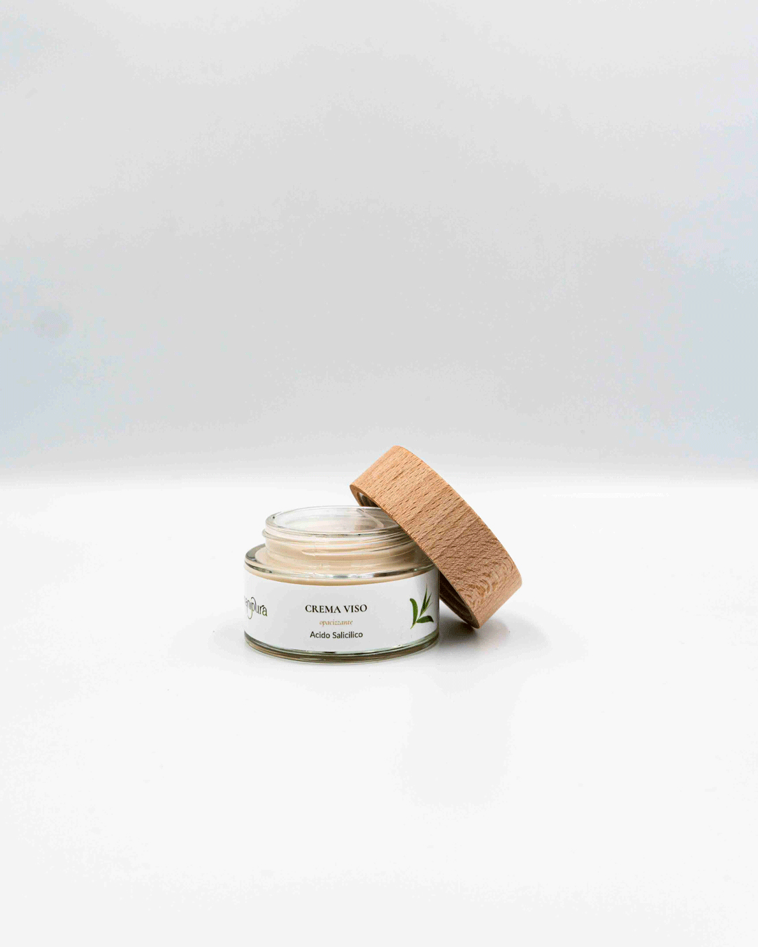 Vasetto in vetro contenente crema viso purificante all'acido salicilico con il tappo aperto.