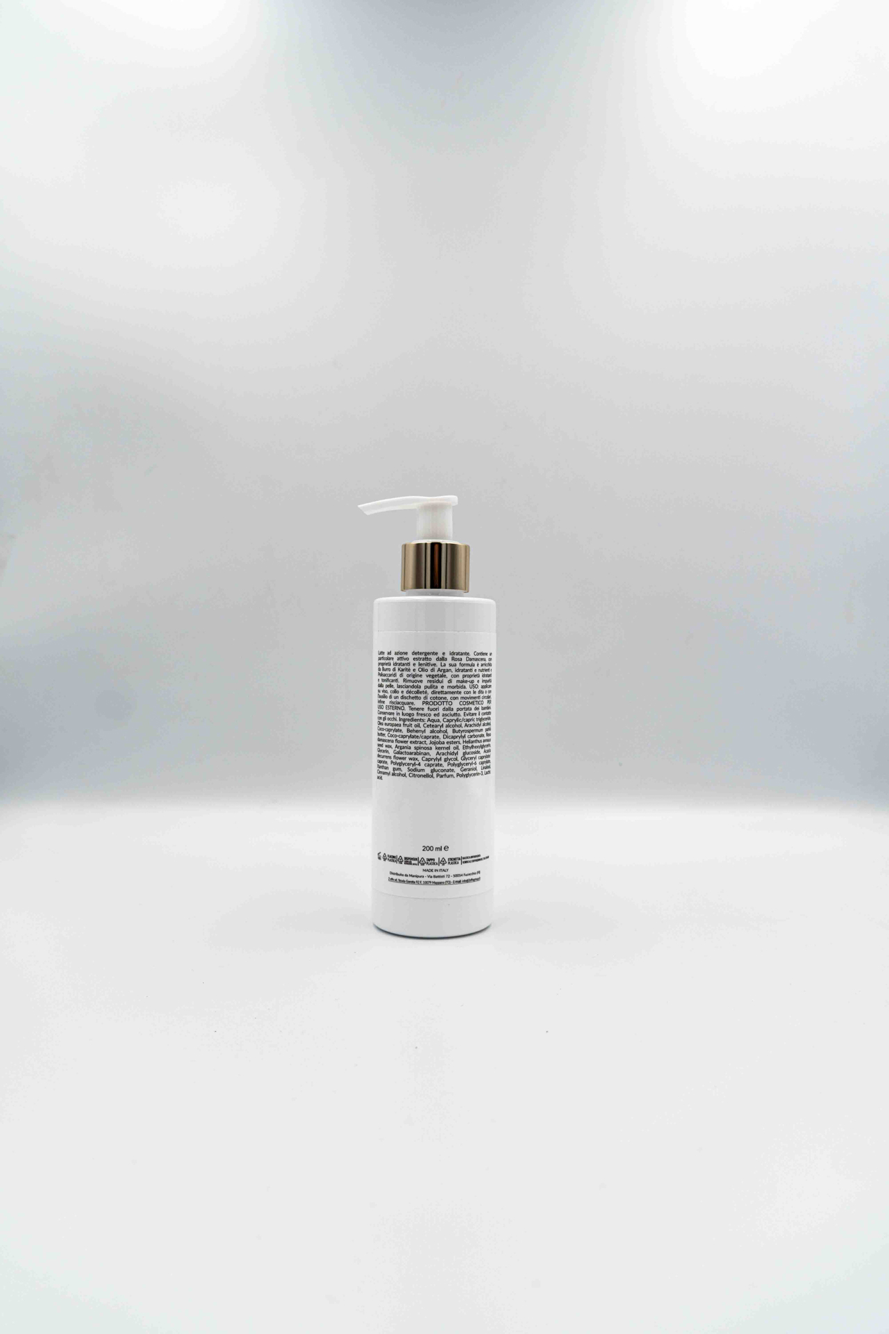 Retro del flacone del latte detergente idratante Manipura da 200 ml, con etichetta ingredienti leggibile e dispenser bianco, su sfondo chiaro.